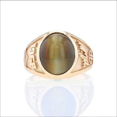 This ring was made by Fox Fine Jewelry for a man who lost his brother in the Vietnam war. It has the year, his signature, a football underneath (he was a football player), and his birthstone. The tiger's eye was from a ring the brother bought in Vietnam.
